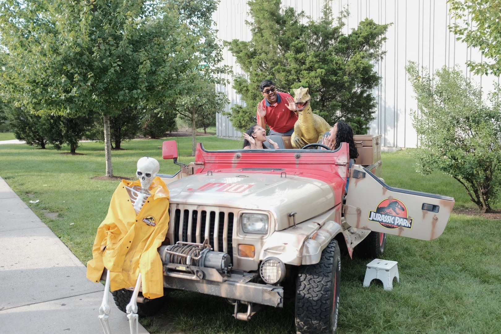 Guests pose in a model of the Jurassic Park Jeep