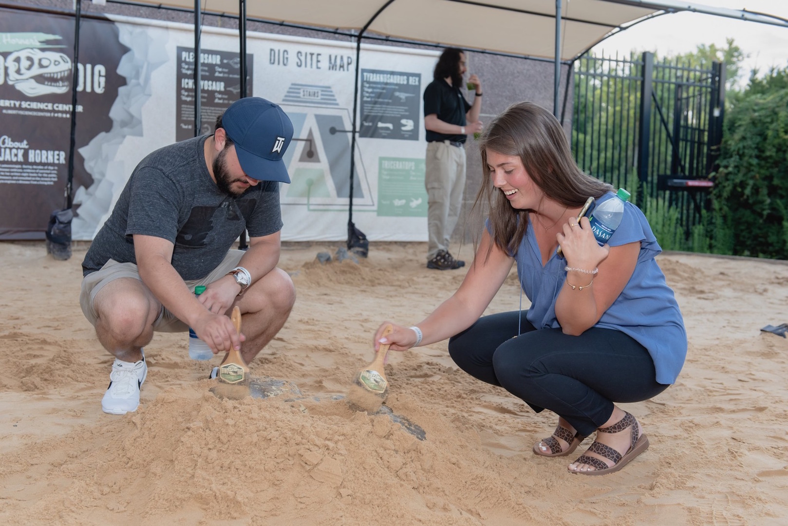 A man and woman dig for fossils in Dino Dig