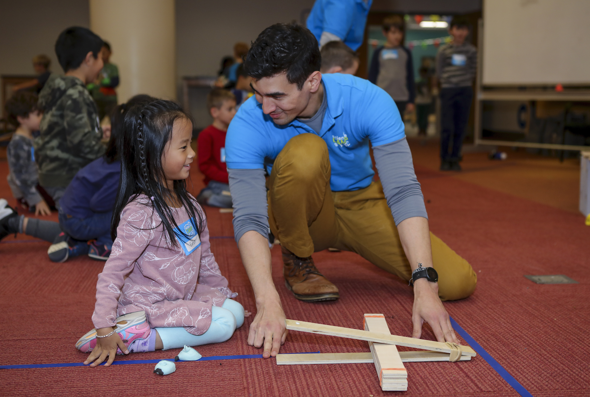 Girl and STEM educator test catapult