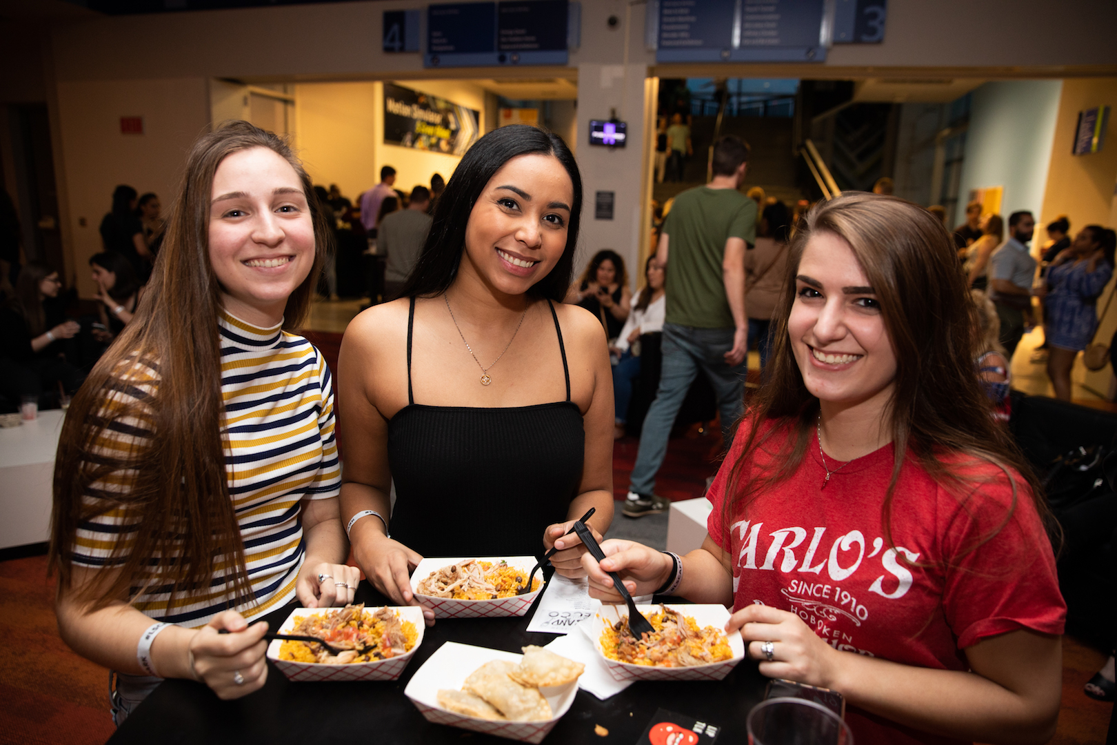Girls enjoying food plates from Midnight Market