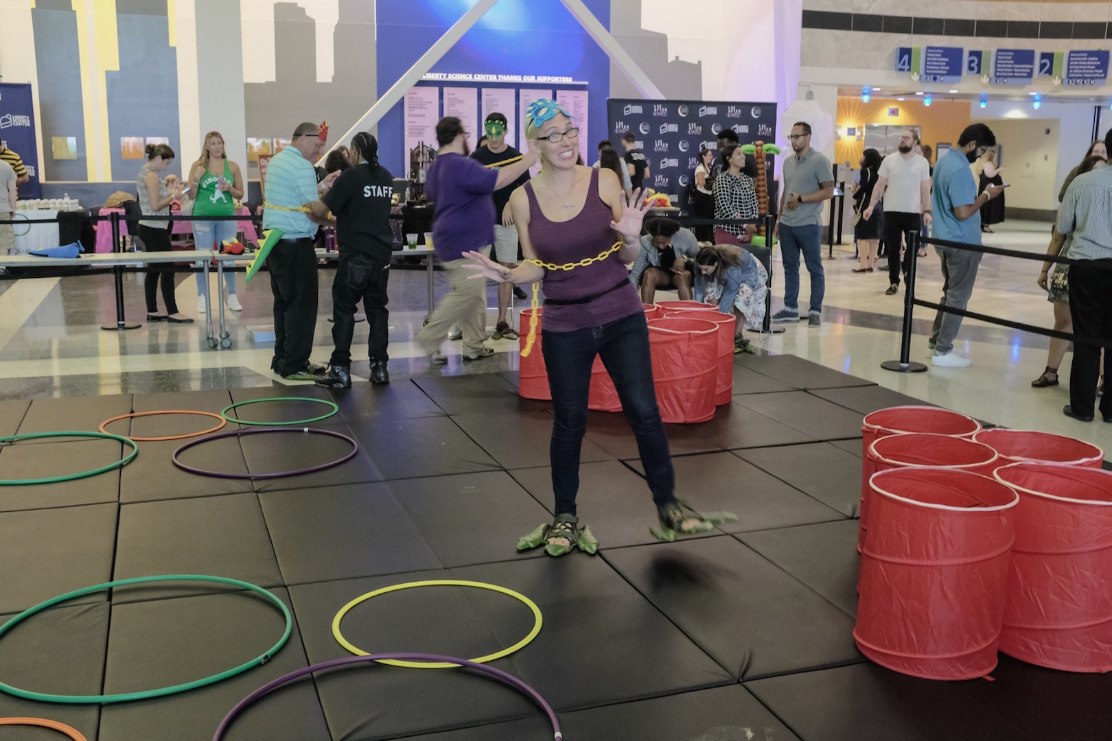 A guest wearing dinosaur feet tries to walk like a dinosaur at the Dino Obstacle Course