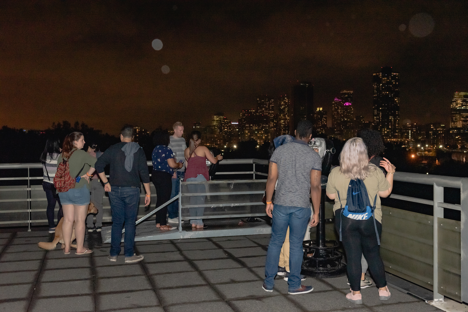 People outside on the balcony enjoying the NYC skyline